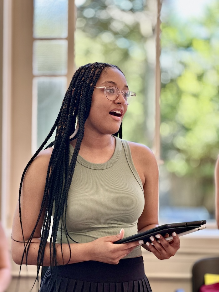 Woman singing with a tablet in her hand